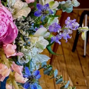 Alstroemères crème réparties dans un bouquet, entre nigelles bleues, delphinium et statice blanc