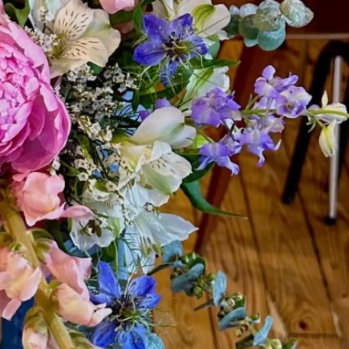 Alstroemères crème réparties dans un bouquet, entre nigelles bleues, delphinium et statice blanc