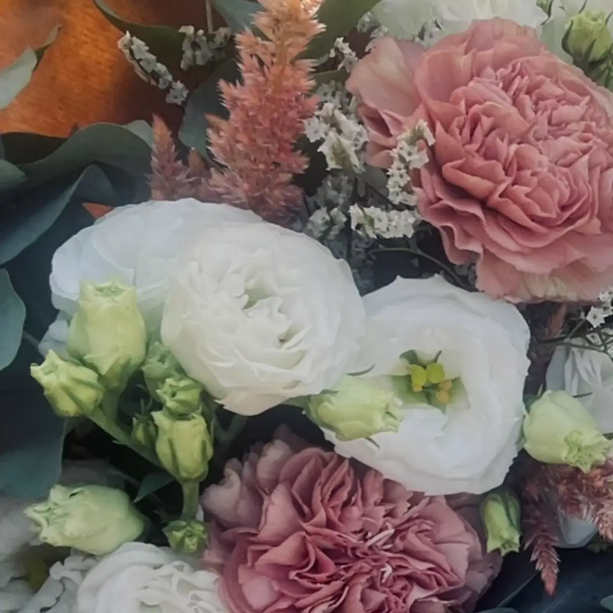 Deux gros œillets rose ancien de part et d'autre de lisianthus blancs, dans un bouquet photographié en plein soleil