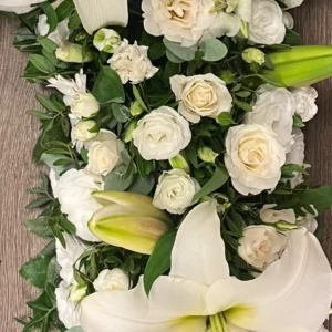 Roses branchues blanc crème portant plusieurs fleurs et boutons par tige, piquées serré dans une composition blanche
